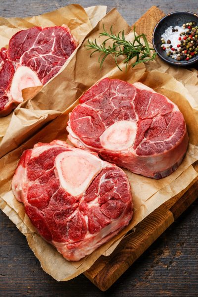 raw-fresh-cross-cut-veal-shank-and-seasonings-for-making-osso-buco-on-wooden-cutting-board.jpg